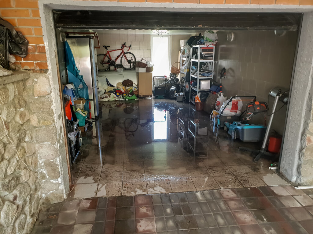 Photo of flooded garage after heavy rain. Wet floor and floating thing in house after flood