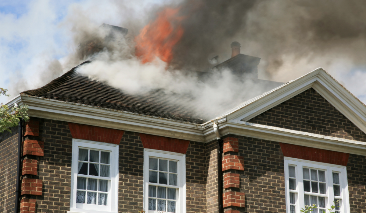 roof of home on fire with smoke