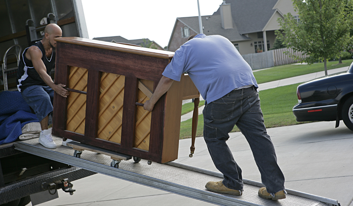 Content Pack-Outs: 2 men loading a piano into a moving truck after home diaster